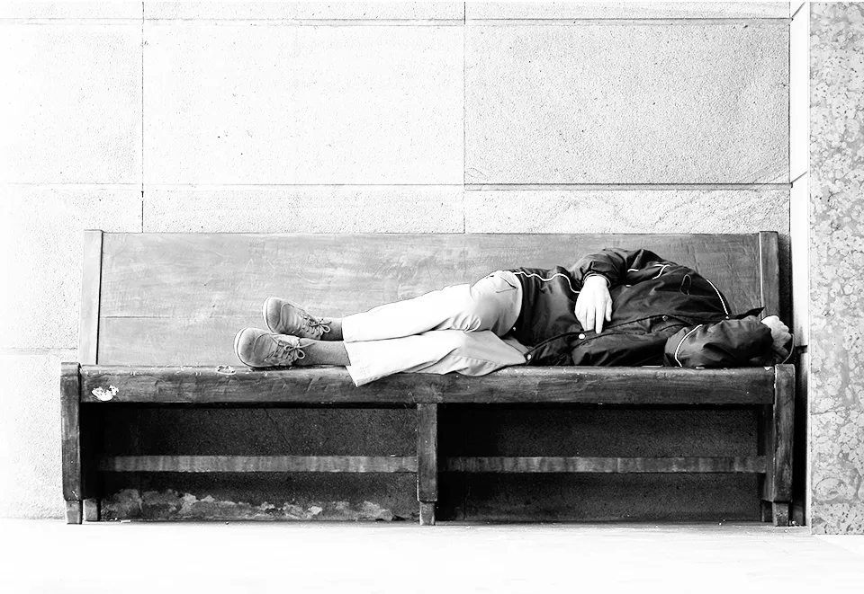 A Homeless Man sleeping on a bench